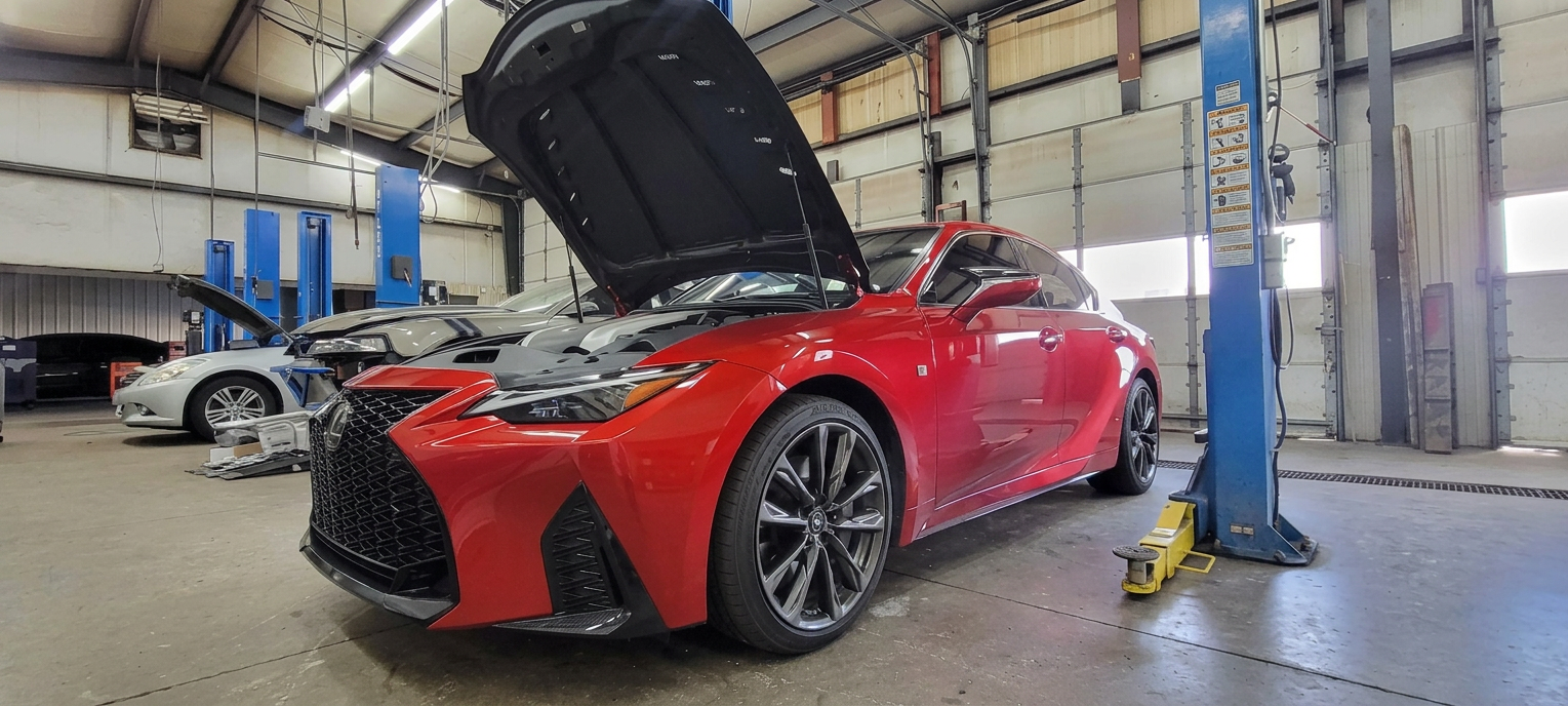 Red Lexus IS F-Sport in the Skylight service bay with hood up